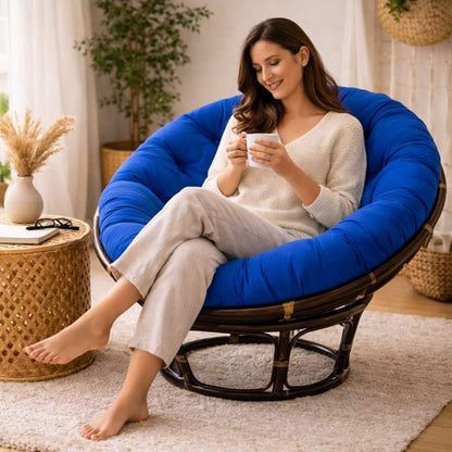 Une femme assise sur e Coussin pour Fauteuil en Rotin rond bleu