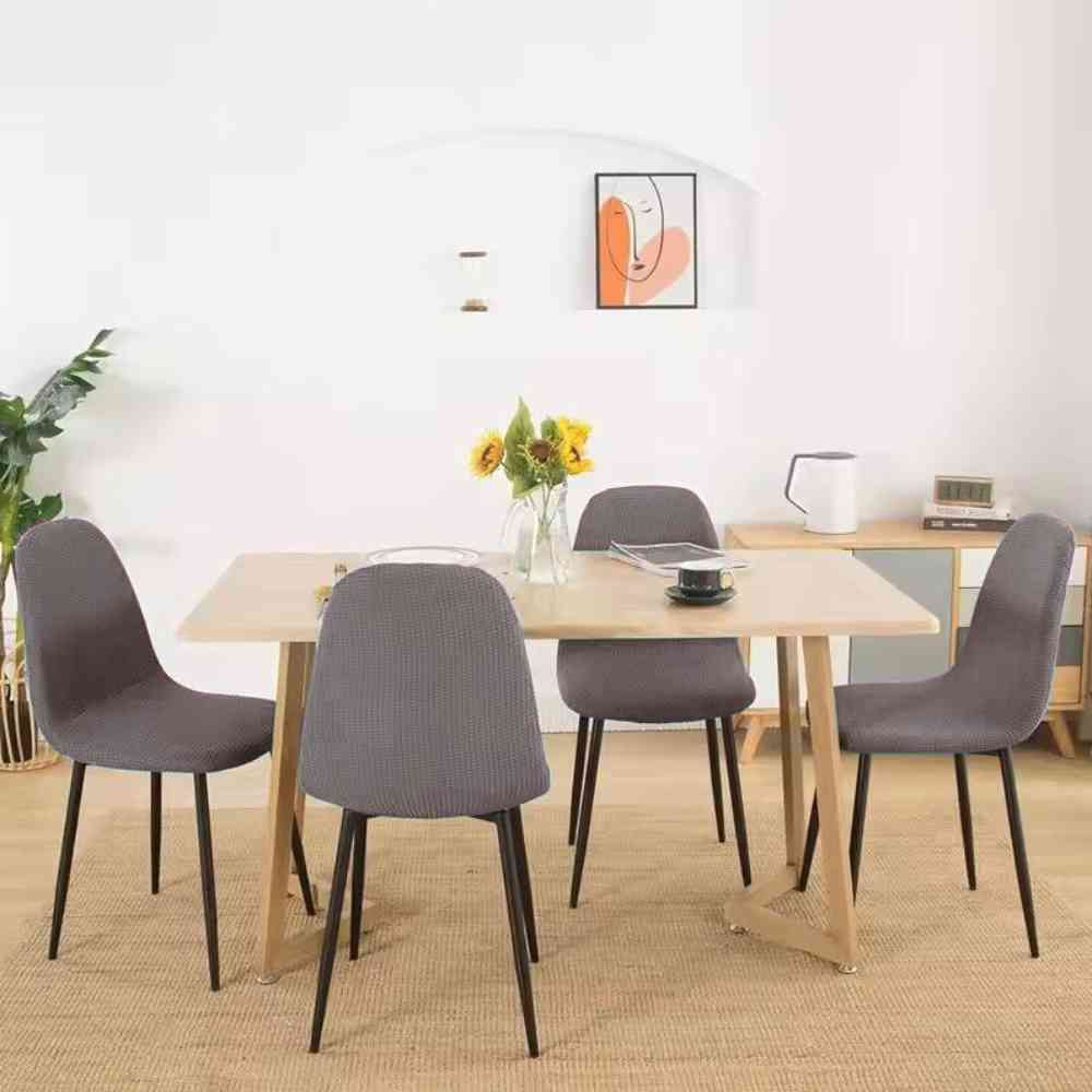 Une belle table de mainson avec des Housses de Chaise Extensible​ Imperméable grise sur des chaises